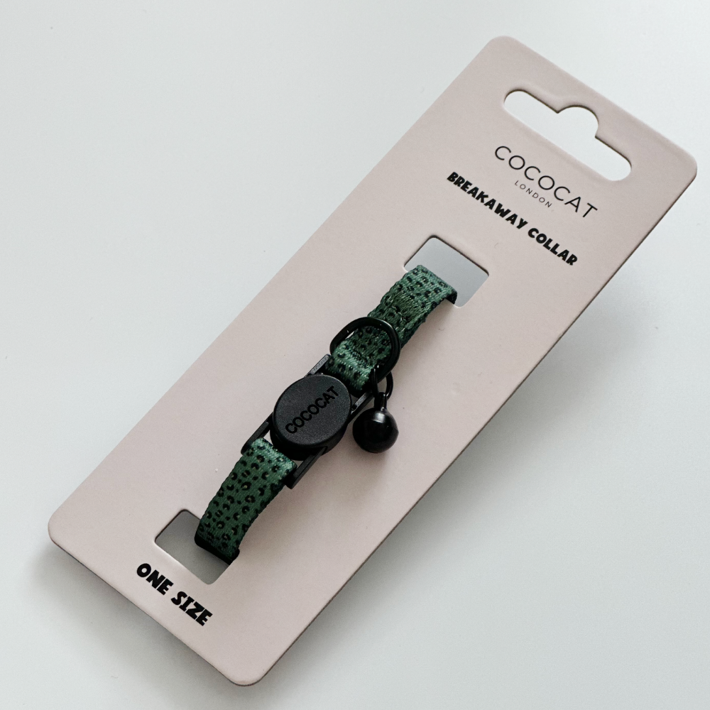 Khaki leopard print cat collar with black breakaway buckle and bell on Cocopup London Breakaway Collar packaging.