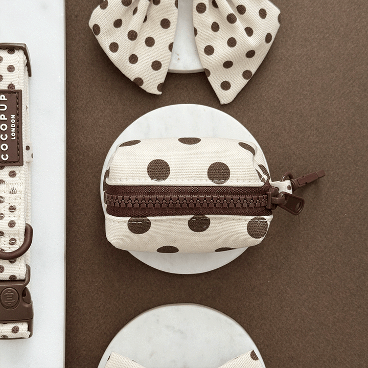 Polka dot pouch with brown zipper on a brown background