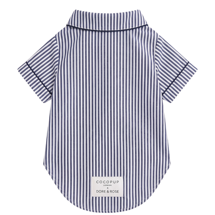 A short-sleeve collared shirt with vertical navy and white stripes, featuring a white brand label at the bottom hem, shown against a plain white background.