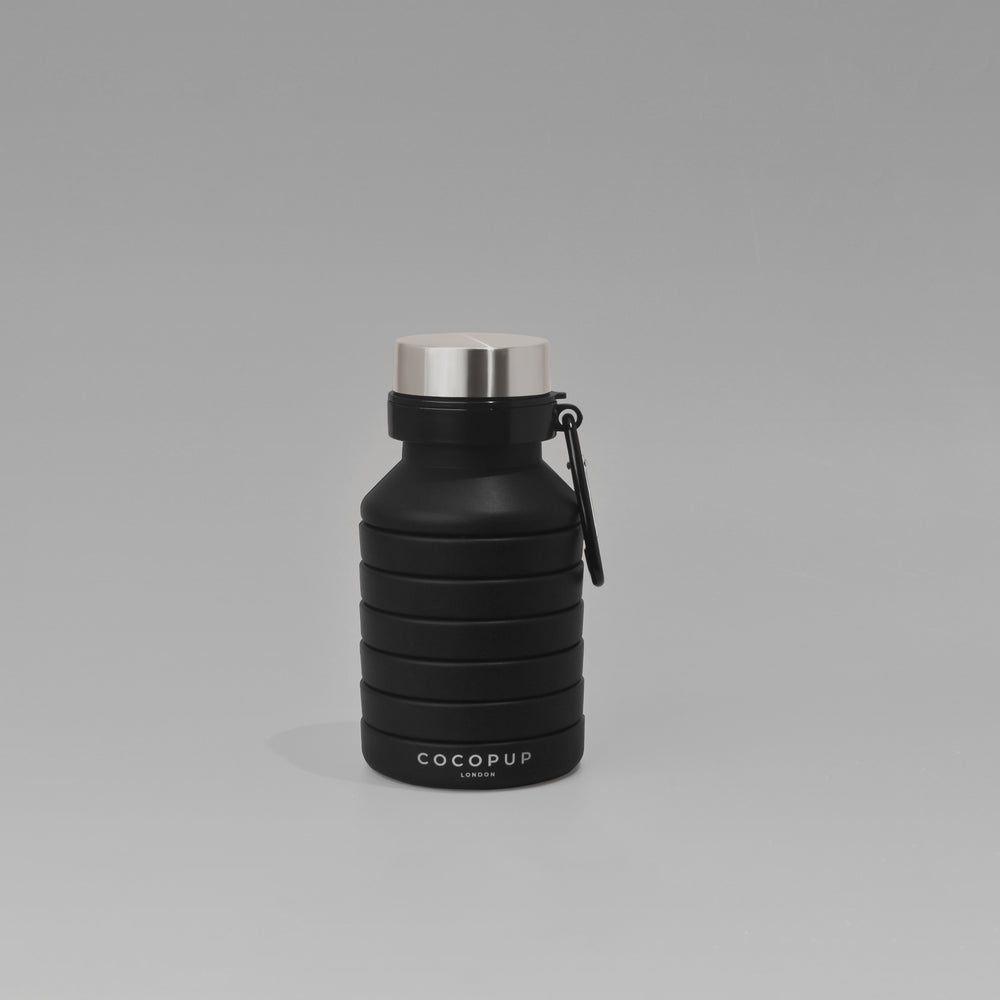 Collapsed view of the Plain Black Silicone Collapsible Water Bottle with Cocopup Branding and Carabiner Clip.