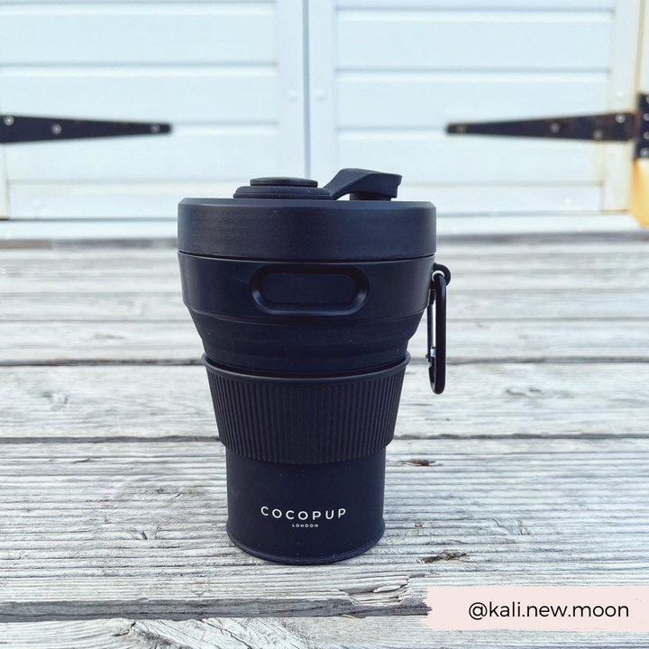 Plain Black Collapsible Silicone Travel Coffee Cup with Cocopup branding and carabiner clip.