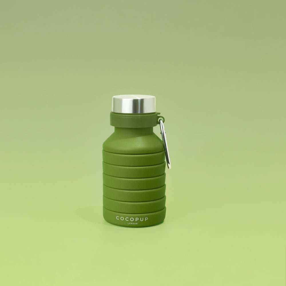 Collapsed view of the Plain Khaki Silicone Collapsible Water Bottle with Cocopup Branding, Stainless Steel Lid and Carabiner Clip.